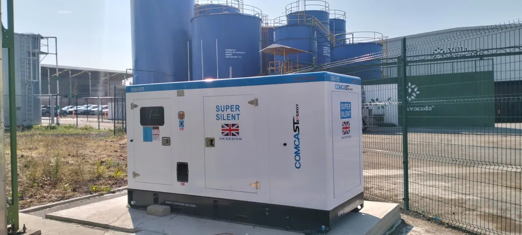 Planta eléctrica Comcast Energy de 150 kW instalada sobre base en una planta industrial con tanques