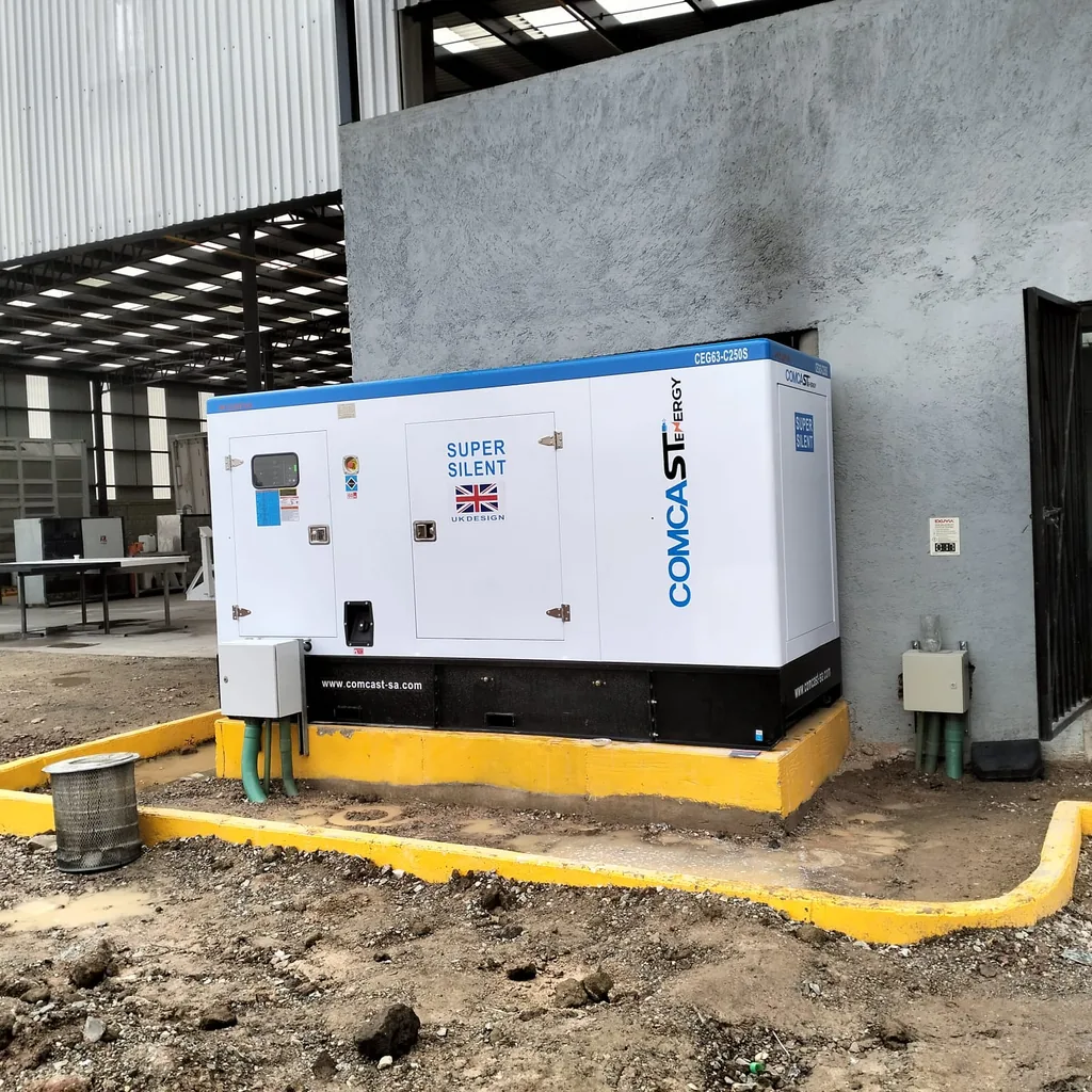 Planta eléctrica Comcast Energy de 200 kW instalada sobre base junto a un edificio industrial